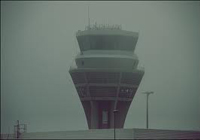 Torre de control de aeropuerto con niebla